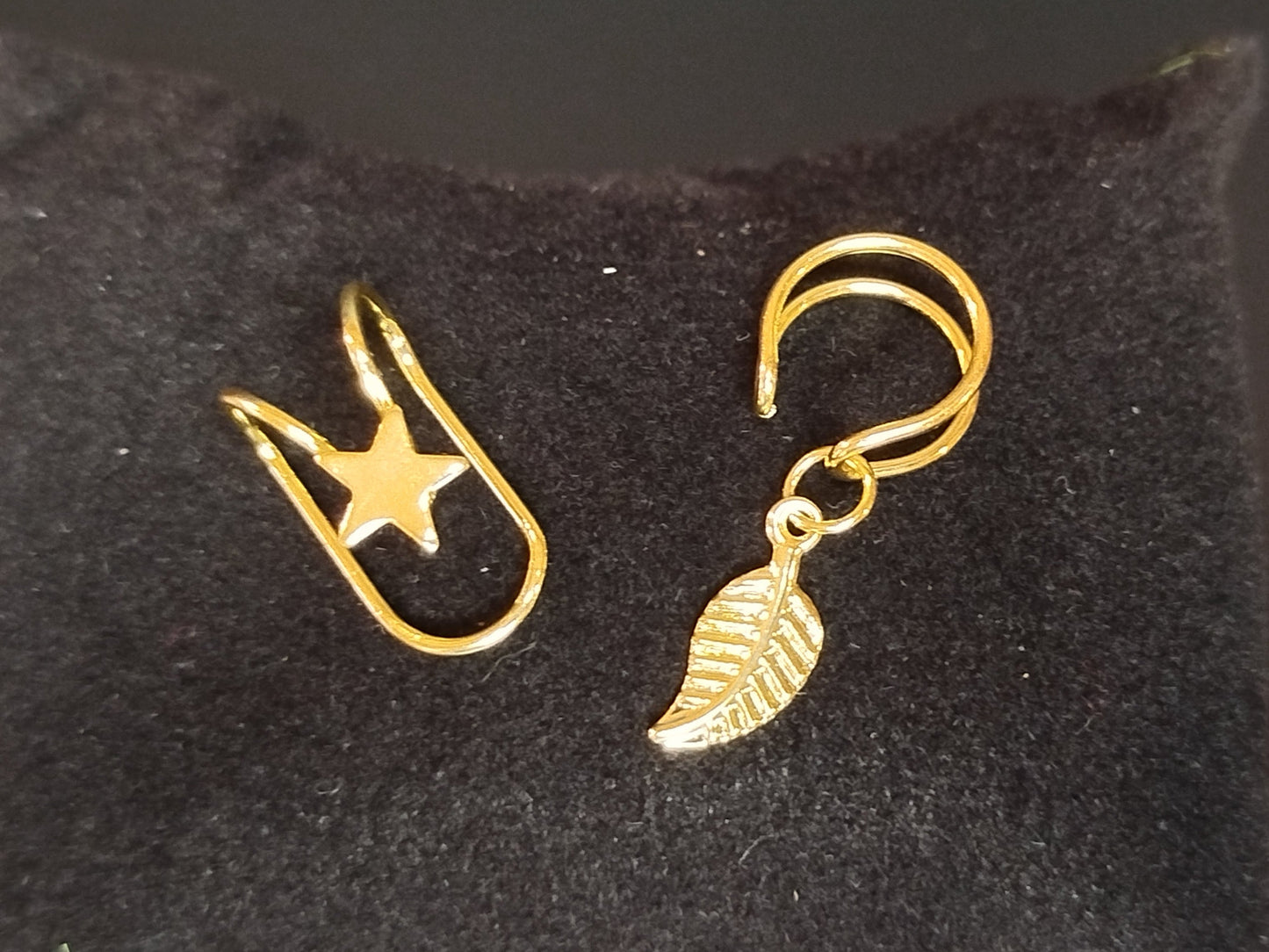 Gold earrings on a black velvet stand