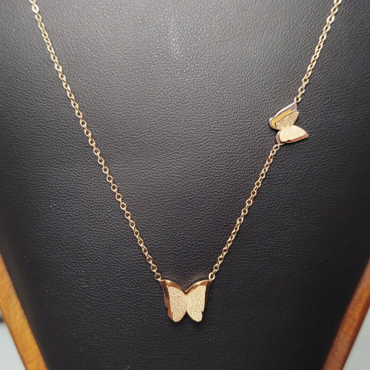 Gold butterfly necklace on a black jewelry display