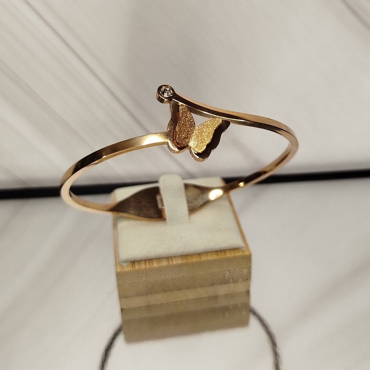 Gold armring on a white stand with a white background
