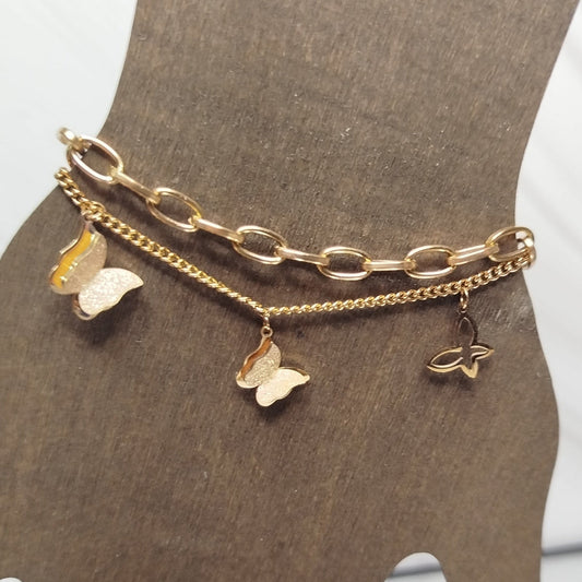 Gold chain bracelet with butterfly charms on a mannequin hand.