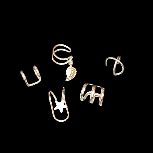 Set of silver ear cuffs on a dark gray background