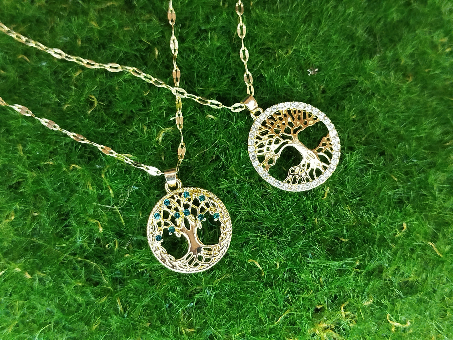 Tree of Life necklace with gold and silver elements on a green textured background