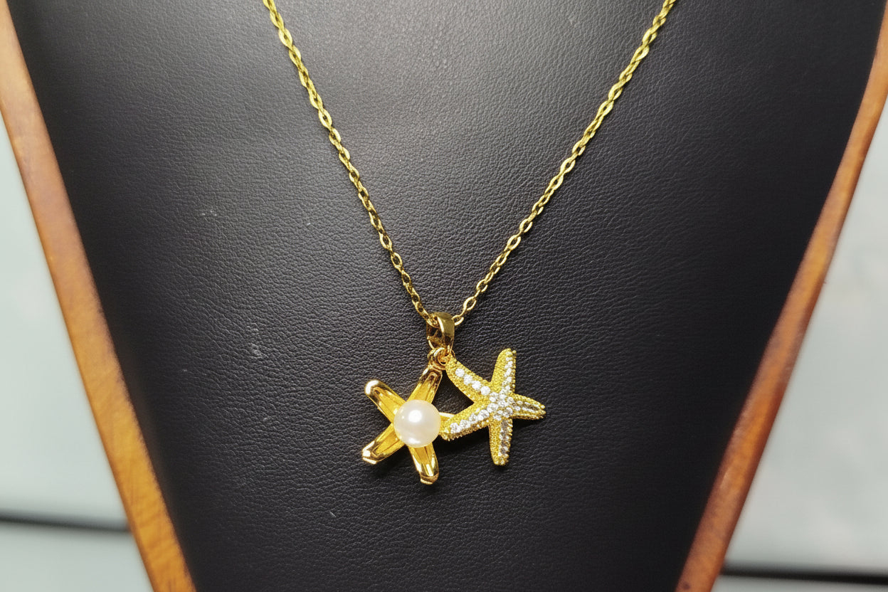 Gold necklace with a star-shaped pendant on a black jewelry display.