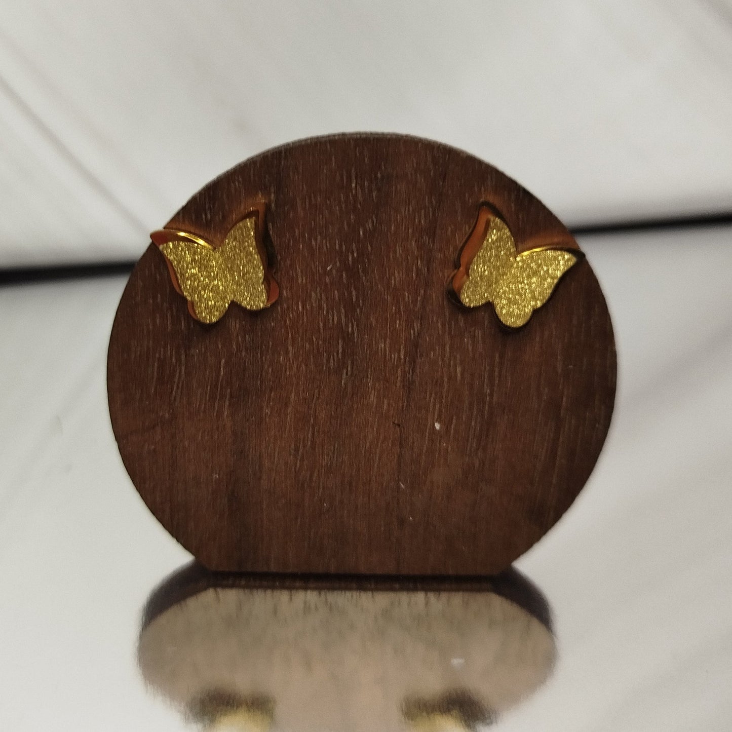 Wooden earring display with gold butterfly earrings